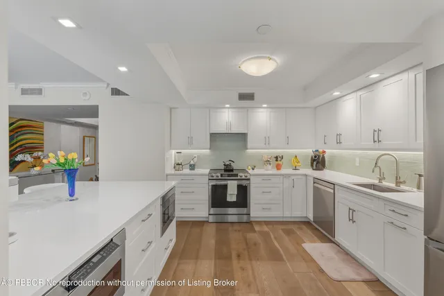 a kitchen with stove a sink and cabinets