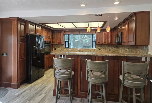 a kitchen with cabinets and chairs