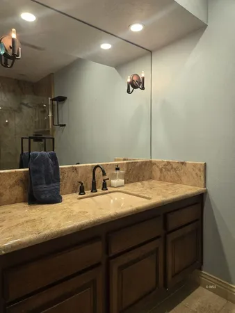 a bathroom with a granite countertop sink and a mirror