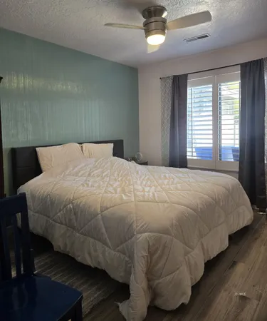 a bedroom with a bed and wooden floor