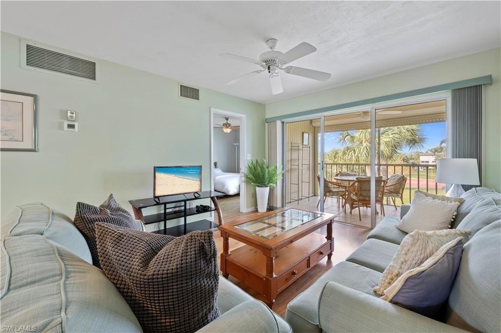 1018 Manatee Road, Unit E302 Naples, FL 34114 - Photo 1 of 19 Living area featuring ceiling fan and wood finished floors