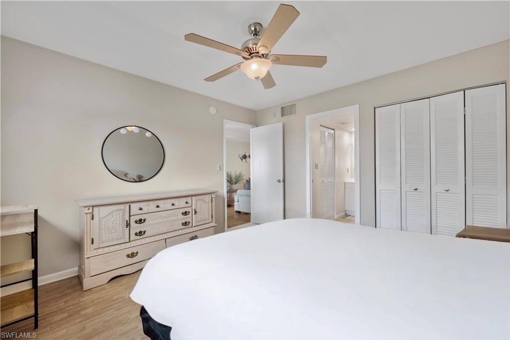 1018 Manatee Road, Unit E302 Naples, FL 34114 - Photo 11 of 19 Bedroom with light wood-style flooring, ensuite bathroom, ceiling fan, and a closet