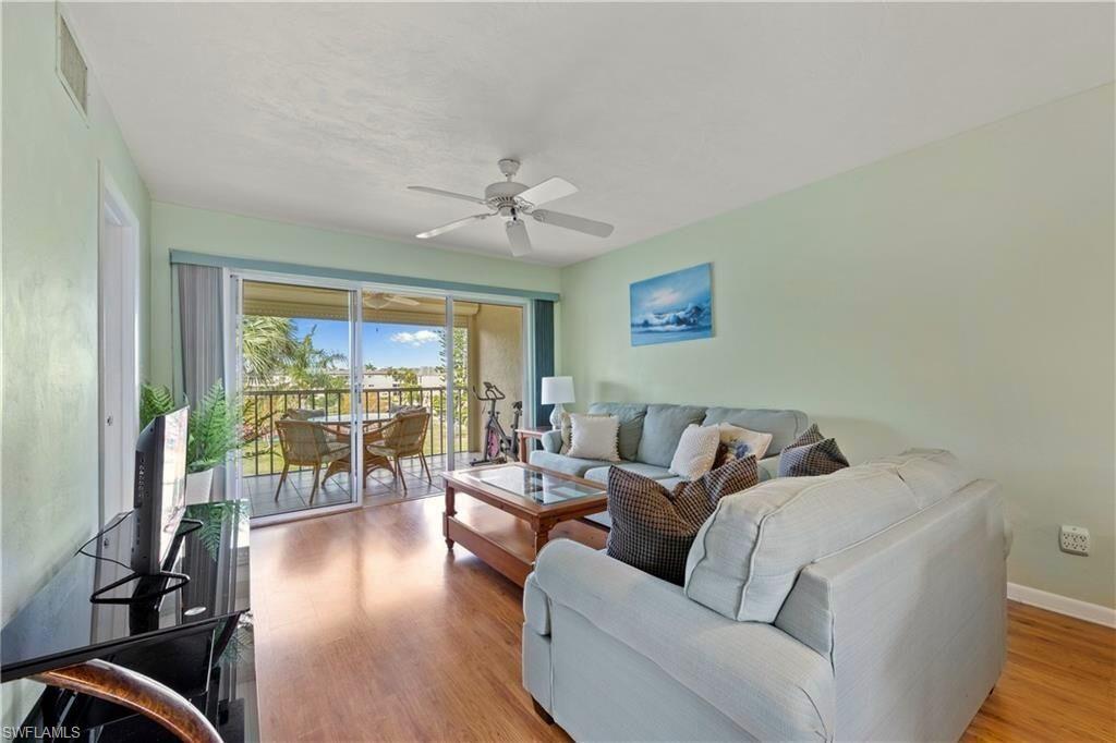 1018 Manatee Road, Unit E302 Naples, FL 34114 - Photo 2 of 19 Living area featuring a ceiling fan and wood finished floors