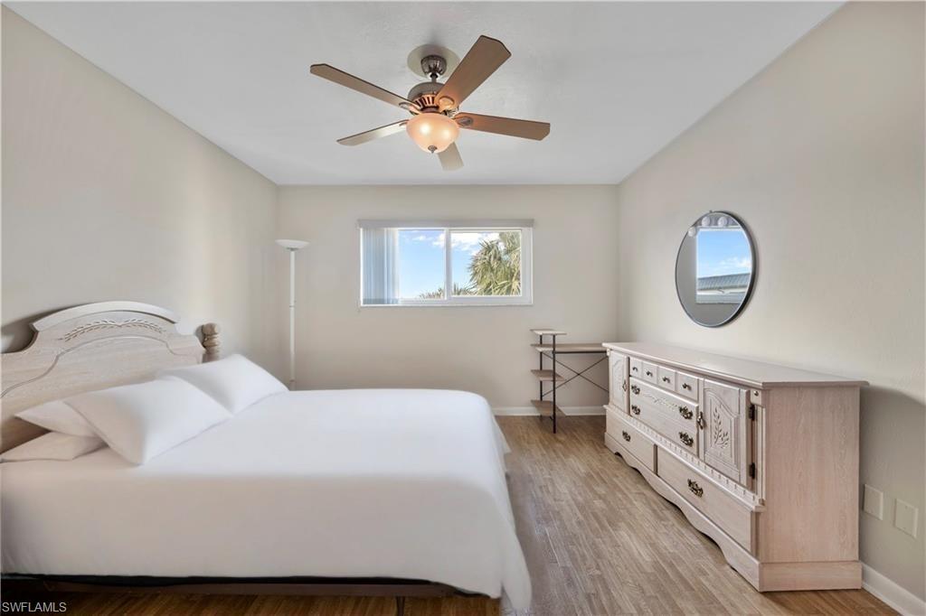 1018 Manatee Road, Unit E302 Naples, FL 34114 - Photo 9 of 19 Bedroom with light wood finished floors and ceiling fan