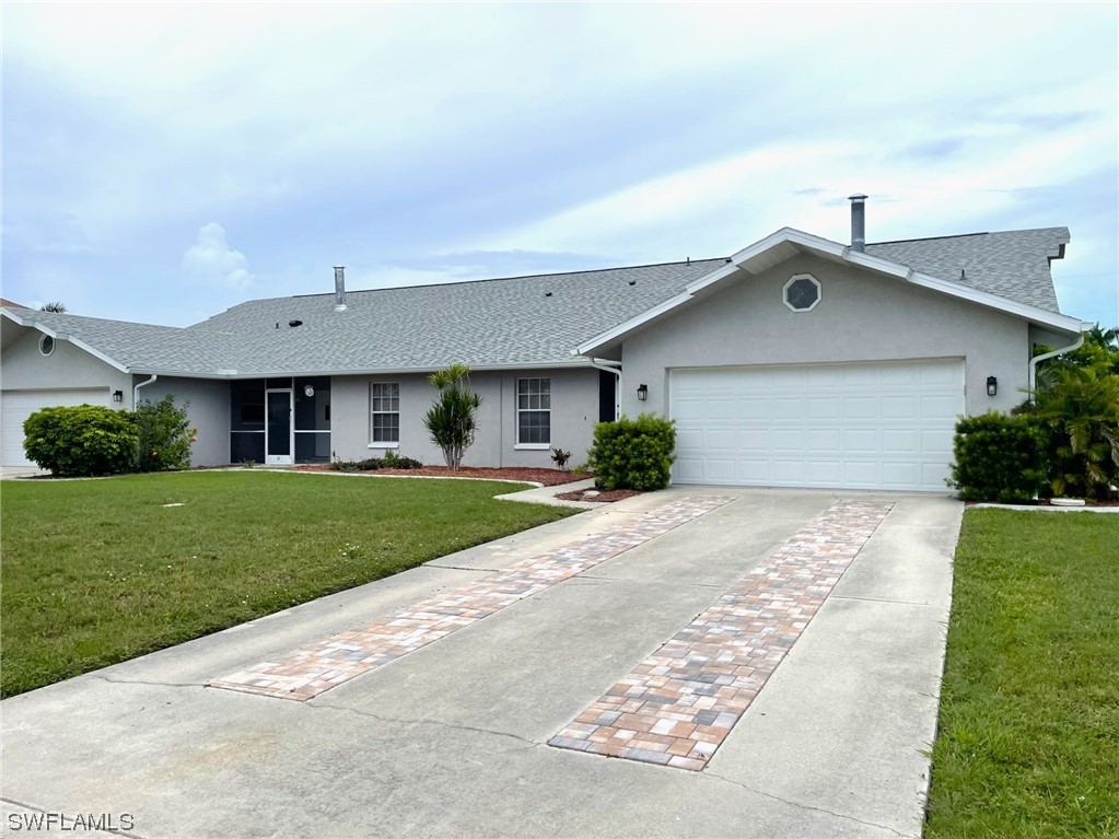 5727 Rose Garden Road, Unit B Cape Coral, FL 33914 - Photo 1 of 26 a front view of a house with a yard and garage