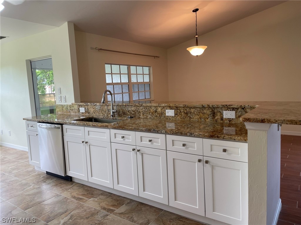 5727 Rose Garden Road, Unit B Cape Coral, FL 33914 - Photo 13 of 26 a kitchen with granite countertop white cabinets and white appliances