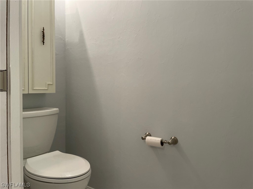 5727 Rose Garden Road, Unit B Cape Coral, FL 33914 - Photo 20 of 26 a white toilet sitting next to a shower
