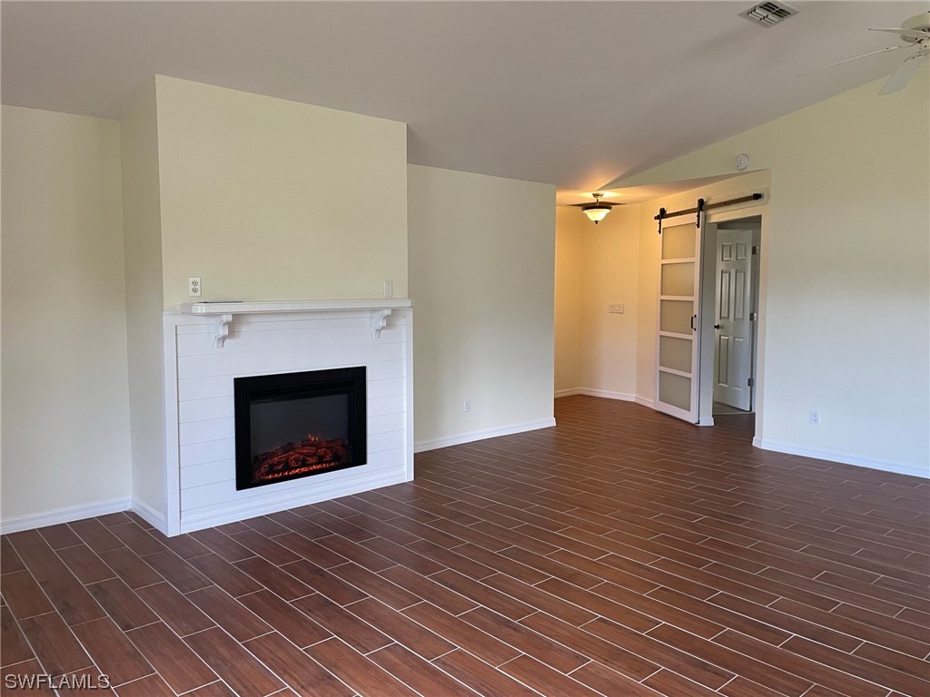 5727 Rose Garden Road, Unit B Cape Coral, FL 33914 - Photo 23 of 26 a view of an empty room with wooden floor fireplace and a window