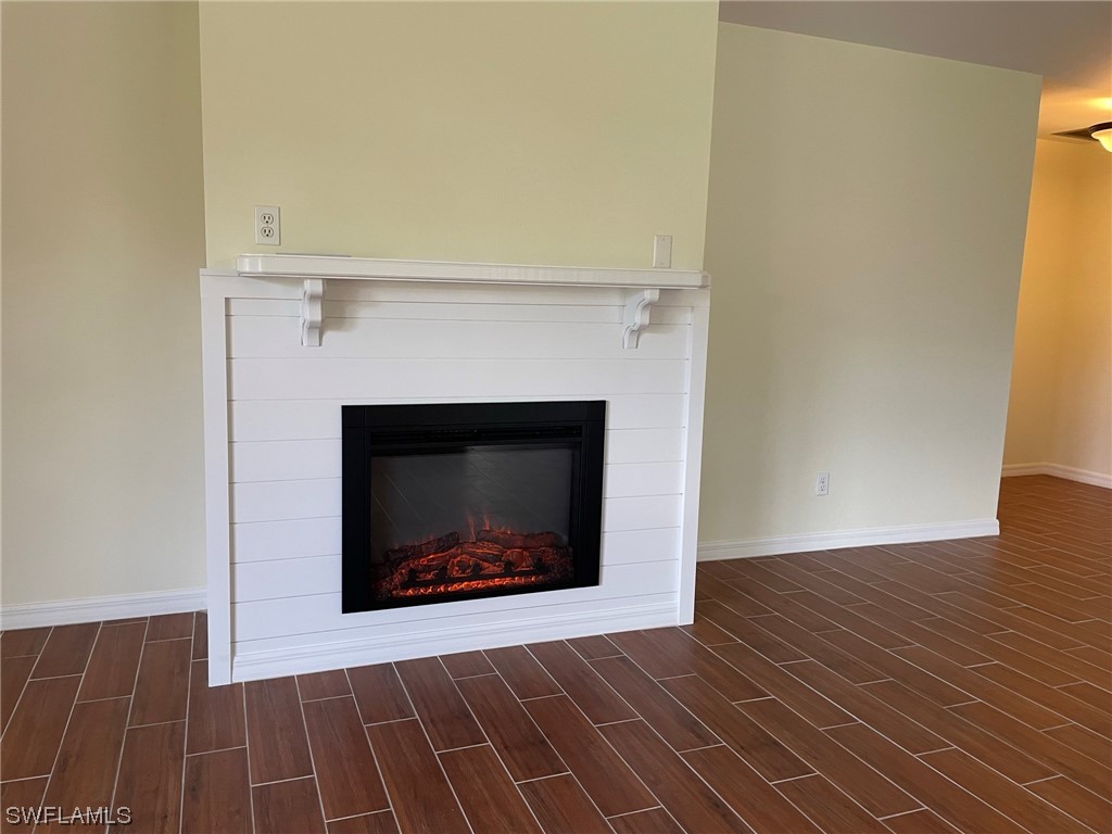5727 Rose Garden Road, Unit B Cape Coral, FL 33914 - Photo 24 of 26 a view of an empty room with wooden floor and a fireplace