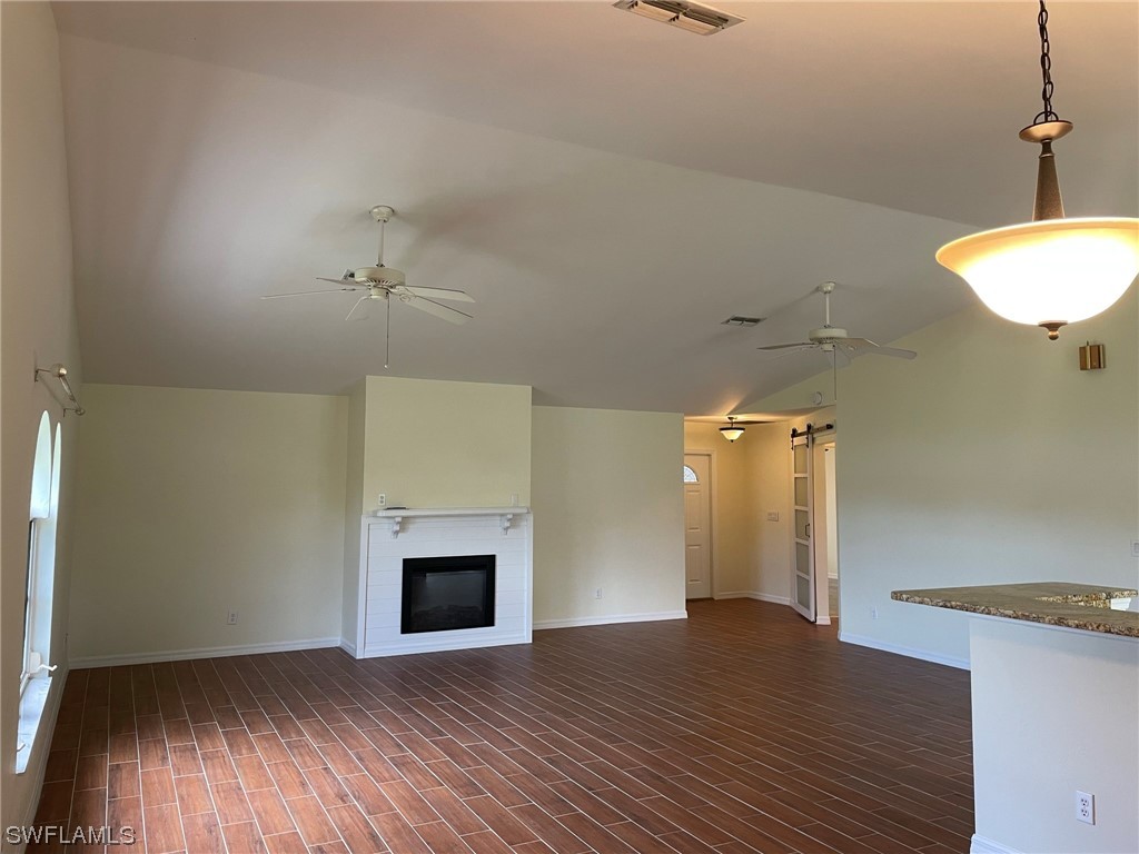 5727 Rose Garden Road, Unit B Cape Coral, FL 33914 - Photo 3 of 26 a view of empty room with wooden floor and fireplace