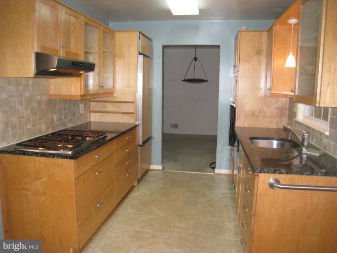 12912 Ruxton Road Silver Spring, MD 20904 - Photo 5 of 10 a kitchen with granite countertop a sink and a refrigerator