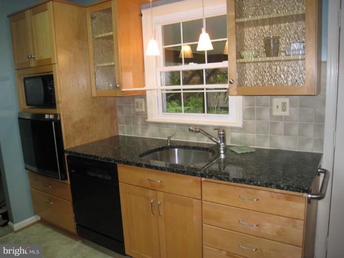 12912 Ruxton Road Silver Spring, MD 20904 - Photo 7 of 10 a kitchen with granite countertop a sink and a refrigerator