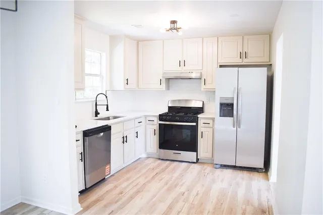 a kitchen with stainless steel appliances a refrigerator stove and sink