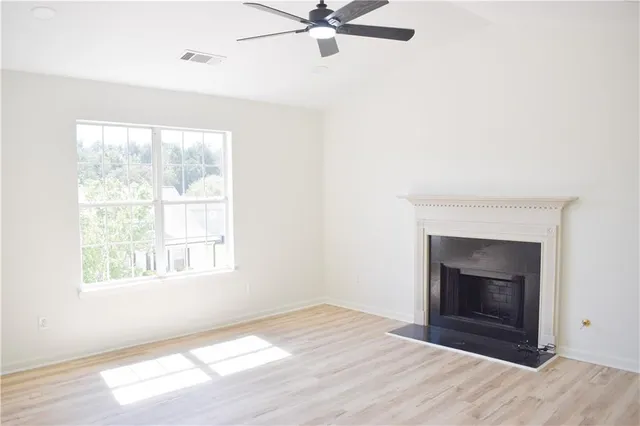 a view of an empty room with a window and fireplace