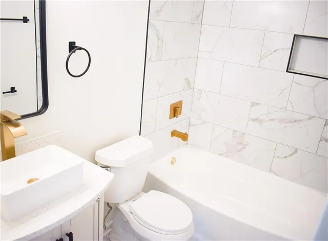 a white toilet sitting next to a bathroom sink