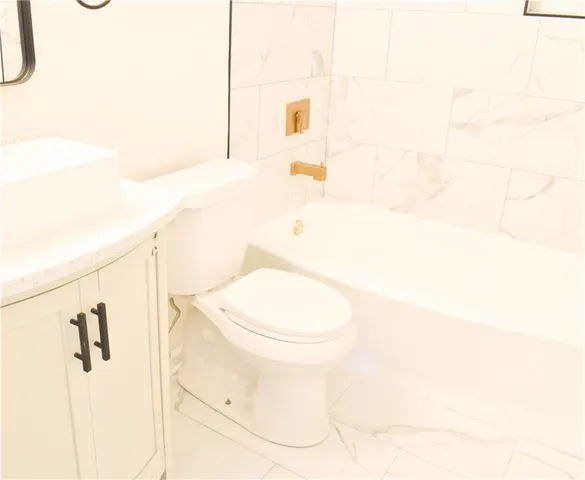 a white toilet sitting next to a bathroom sink