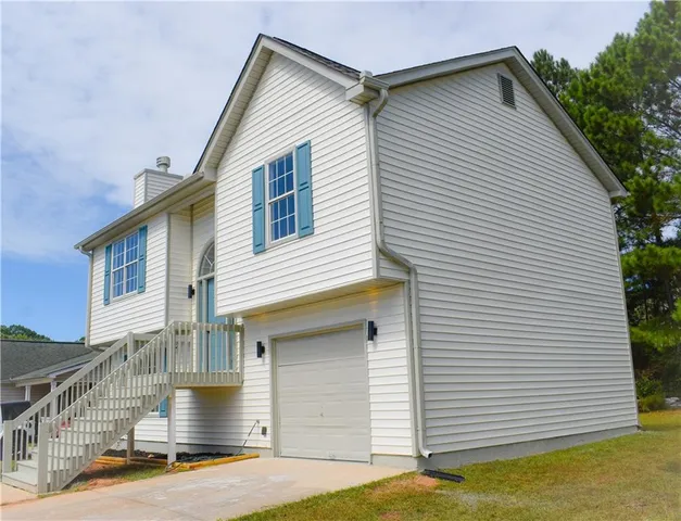 a view of a white house with a small yard and a large window