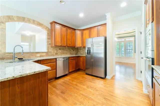 a view of a big room with wooden floor a ceiling fan and windows
