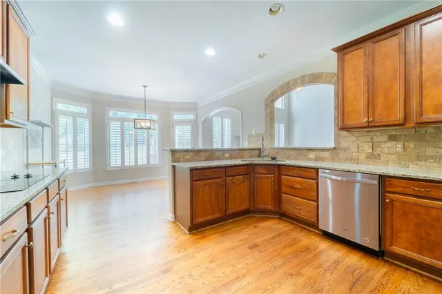 a kitchen with stainless steel appliances granite countertop a stove a sink and a microwave