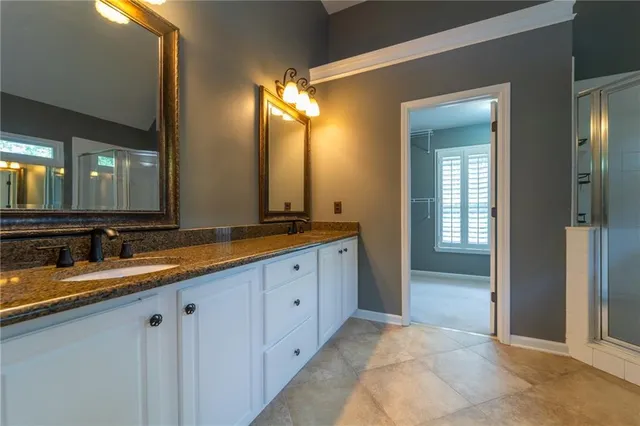a spacious bathroom with a double vanity sink and a mirror