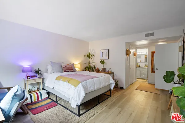 a bed room with a bed and a potted plant