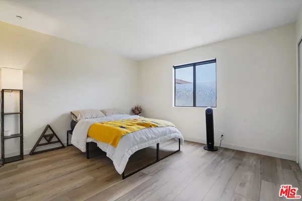 a bedroom with a bed and wooden floor