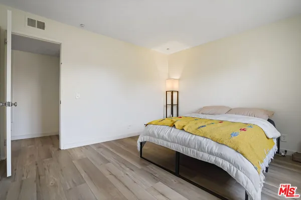 a bed sitting in a bedroom next to a lamp