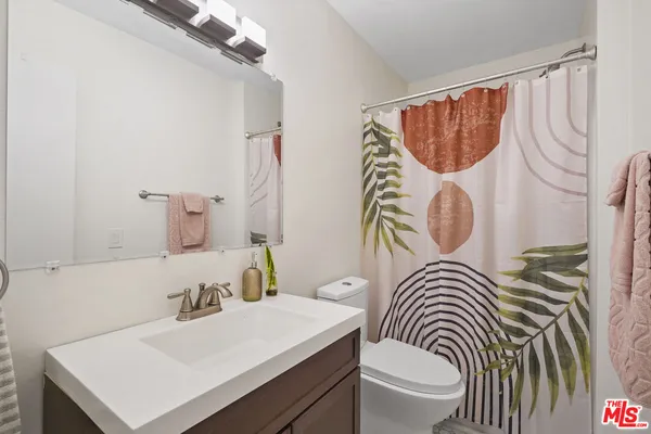 a bathroom with a sink a toilet and a mirror