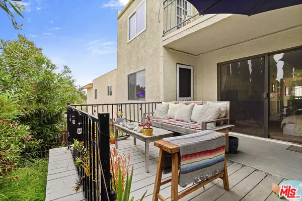 a roof deck with couches and wooden floor