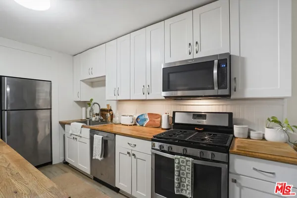 a kitchen with stainless steel appliances granite countertop a stove a refrigerator and a microwave