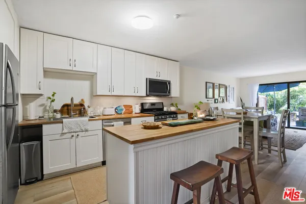 a kitchen with white cabinets stove and sink
