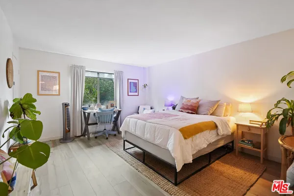 a spacious bedroom with a bed and a potted plant