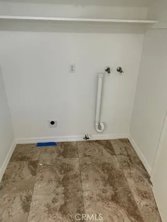 a view of an empty room with wooden floor and windows