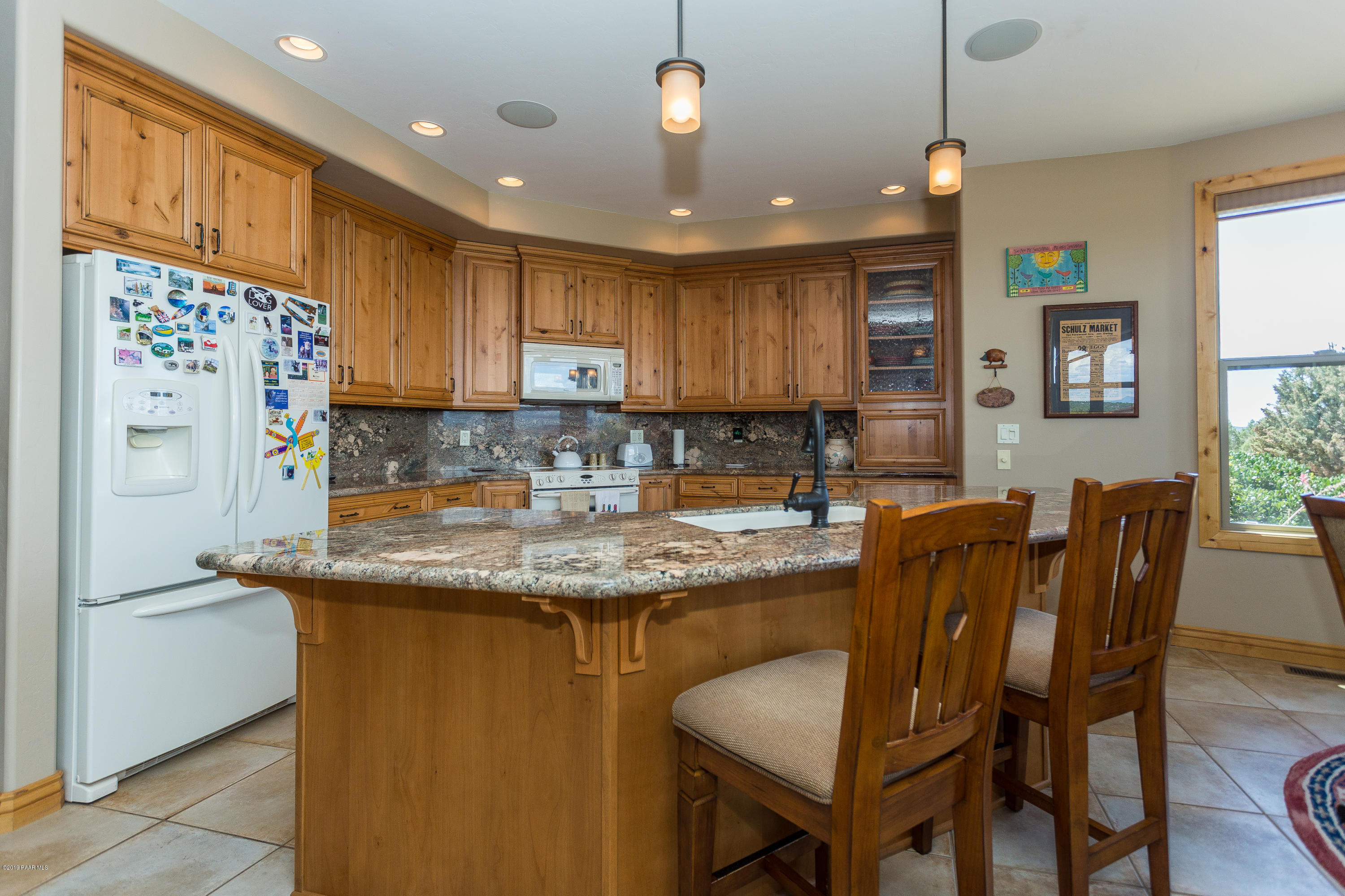 7301 Dillon Wash Road Prescott, AZ 86305 - Photo 9 of 36 a kitchen with stainless steel appliances granite countertop a sink a stove a refrigerator a microwave oven with a dining table and chairs