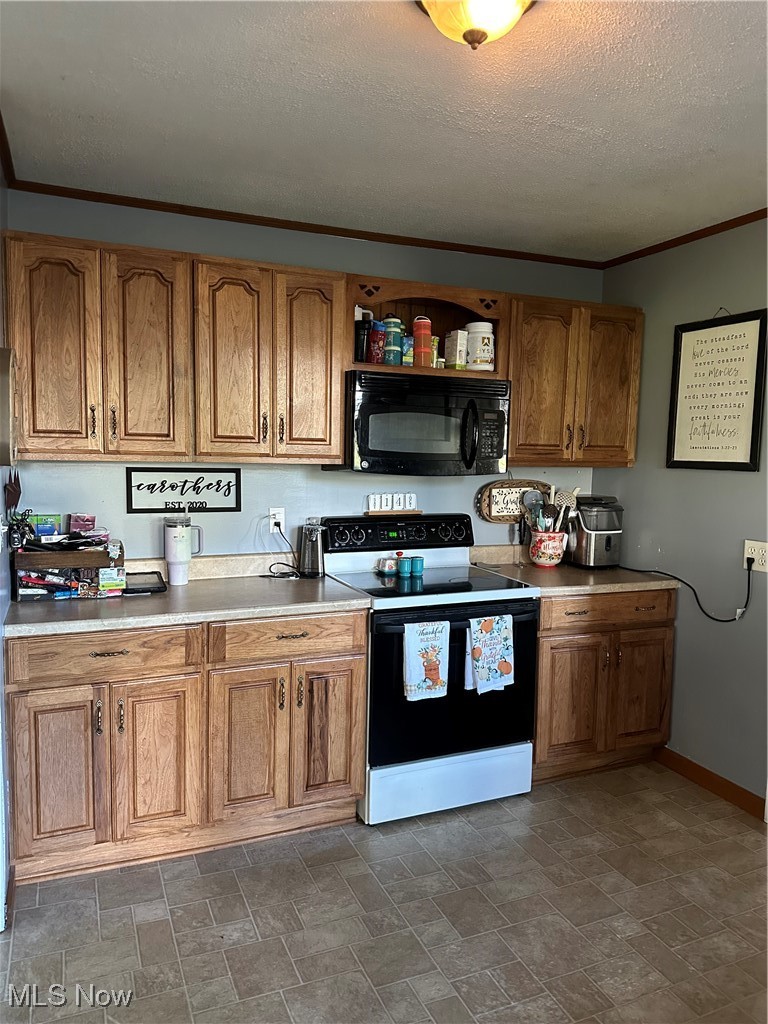 422 Moose Ridge Road Woodsfield, OH 43793 - Photo 13 of 43 Kitchen with range, crown molding, stone finish flooring, brown cabinets, and light countertops