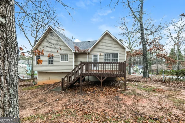 a view of a house with a yard and wooden fence