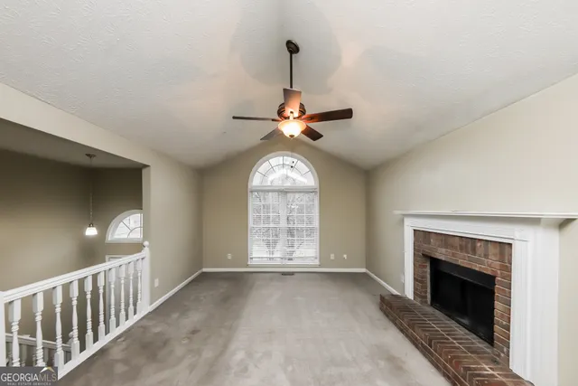 a view of an empty room with a fireplace and a window