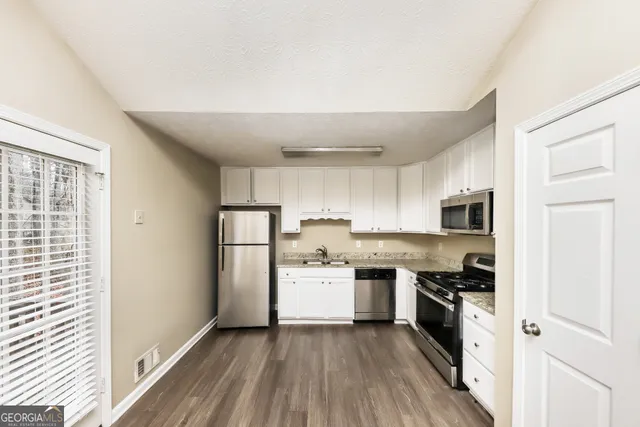 a kitchen with a sink a stove top oven and refrigerator