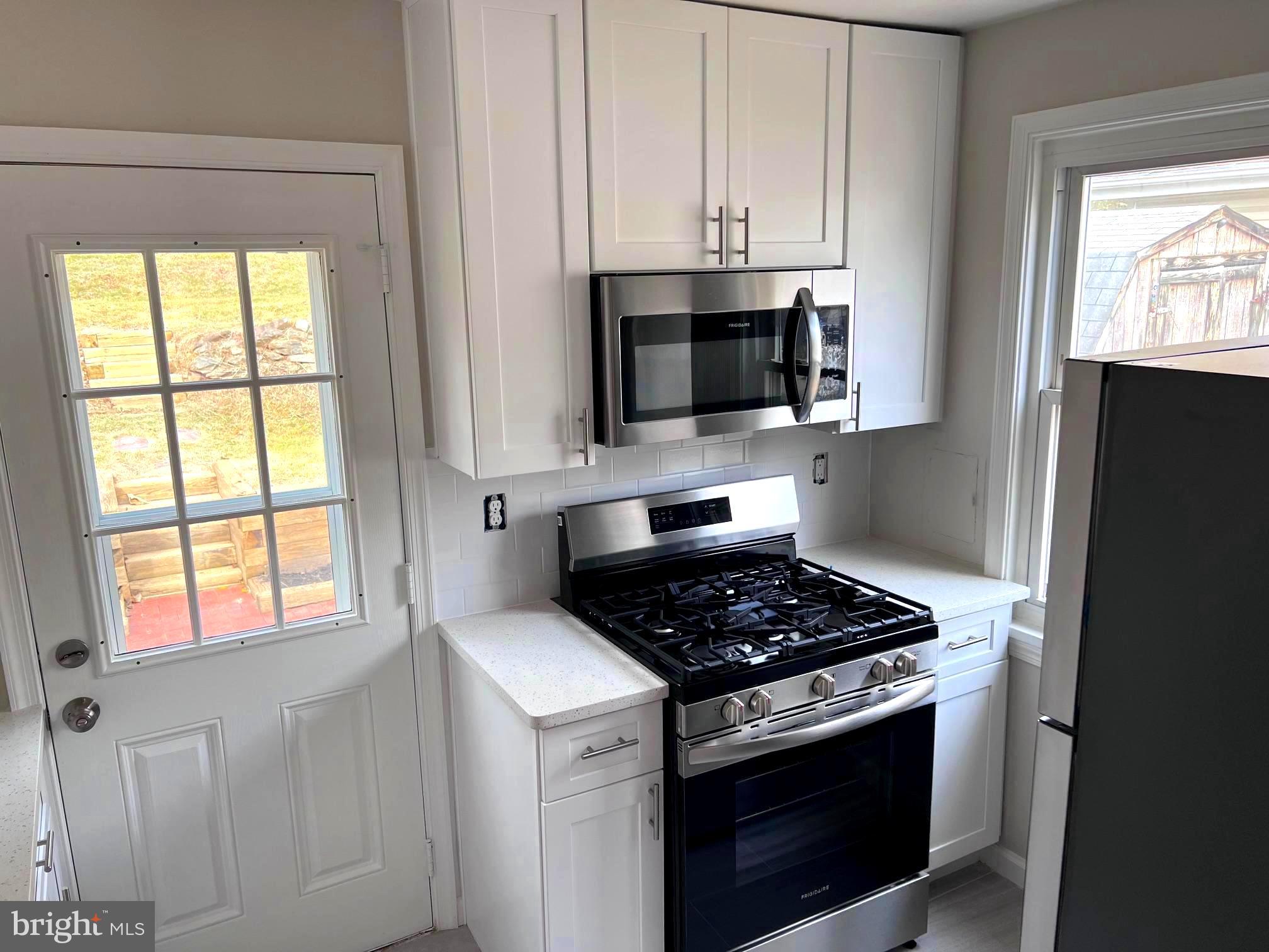 708 Crabb Avenue Rockville, MD 20850 - Photo 8 of 24 a kitchen with stainless steel appliances granite countertop white cabinets a window and a sink