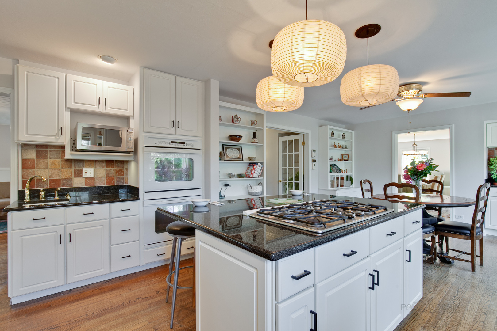 1991 Pheasant Trail Inverness, IL 60067 - Photo 20 of 53 a kitchen with stainless steel appliances granite countertop a stove a sink dishwasher and a dining table with wooden floor