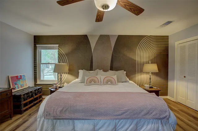 a bedroom with a bed and wooden floor