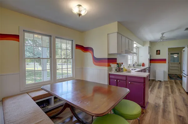 a kitchen with wooden cabinets a sink a stove and a window