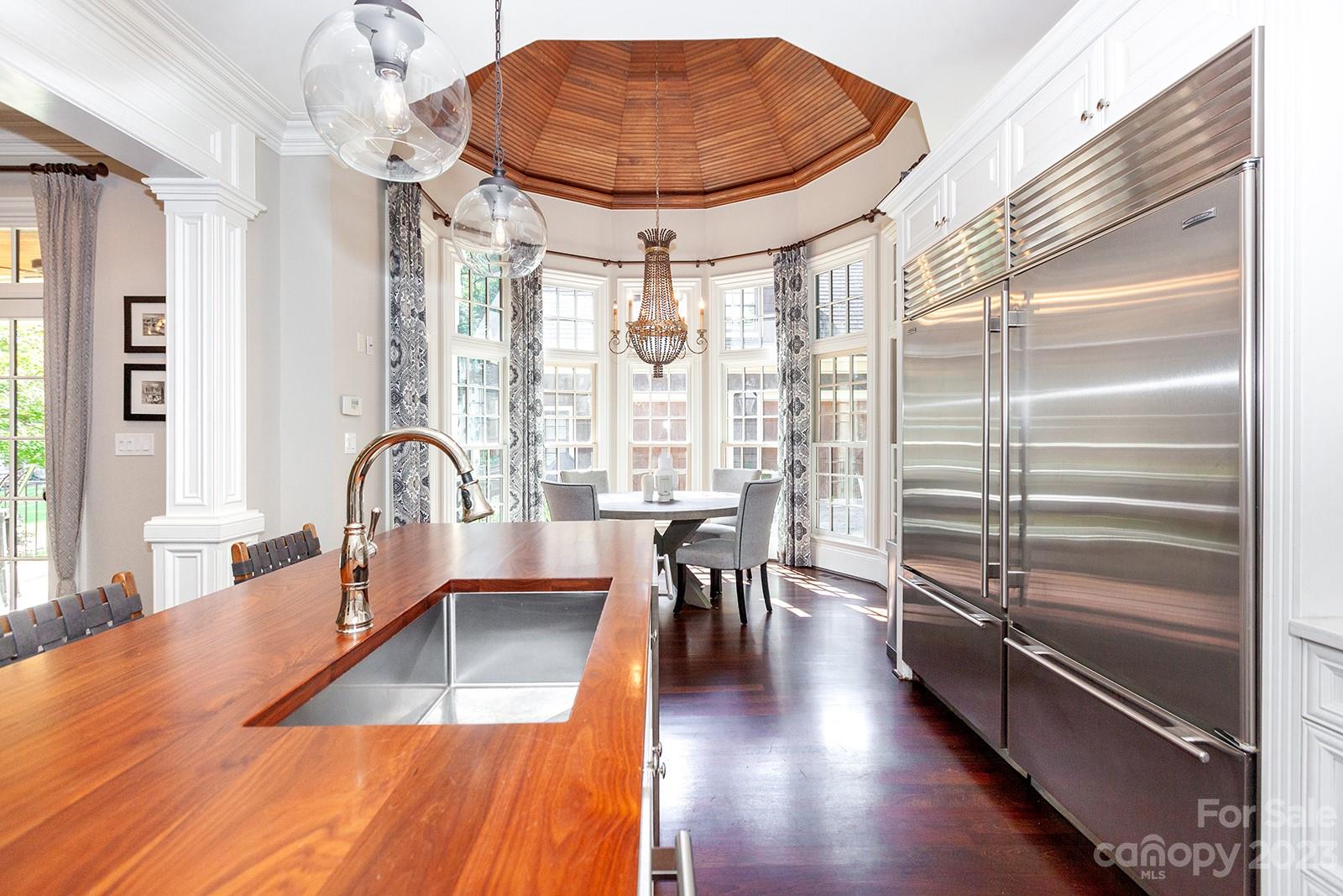 1925 Shoreham Drive Charlotte, NC 28211 - Photo 6 of 48 a dining hall with stainless steel appliances granite countertop a stove a sink a dining table and chairs with wooden floor