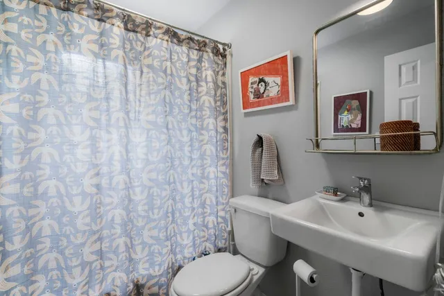 a bathroom with a toilet sink and mirror