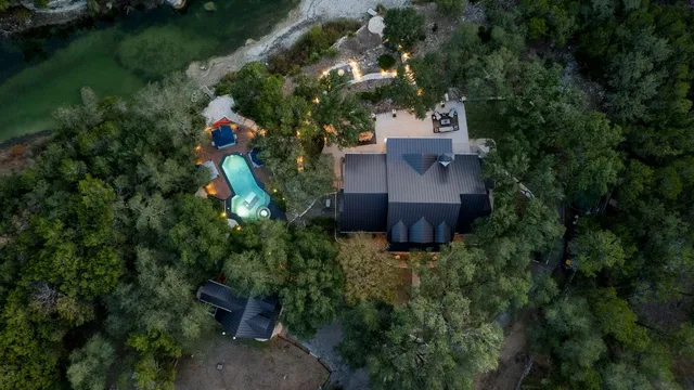 an aerial view of a house with a yard and lake view