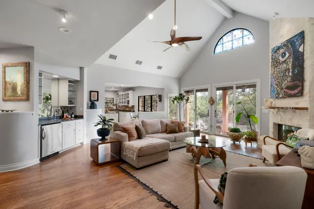 a living room with furniture fireplace and a large window
