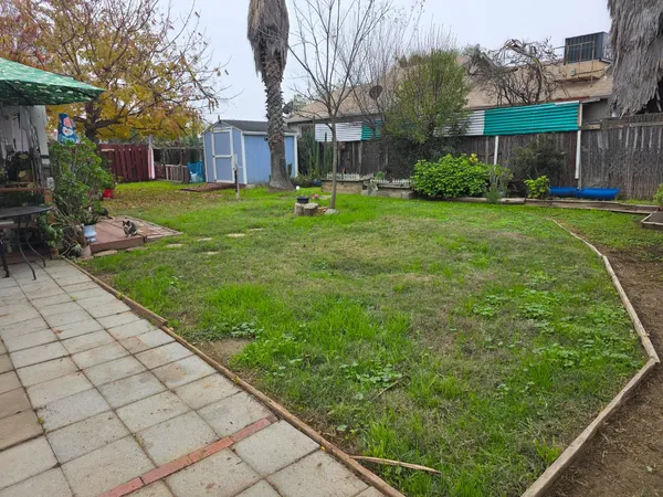 a backyard of a house with garden and trees