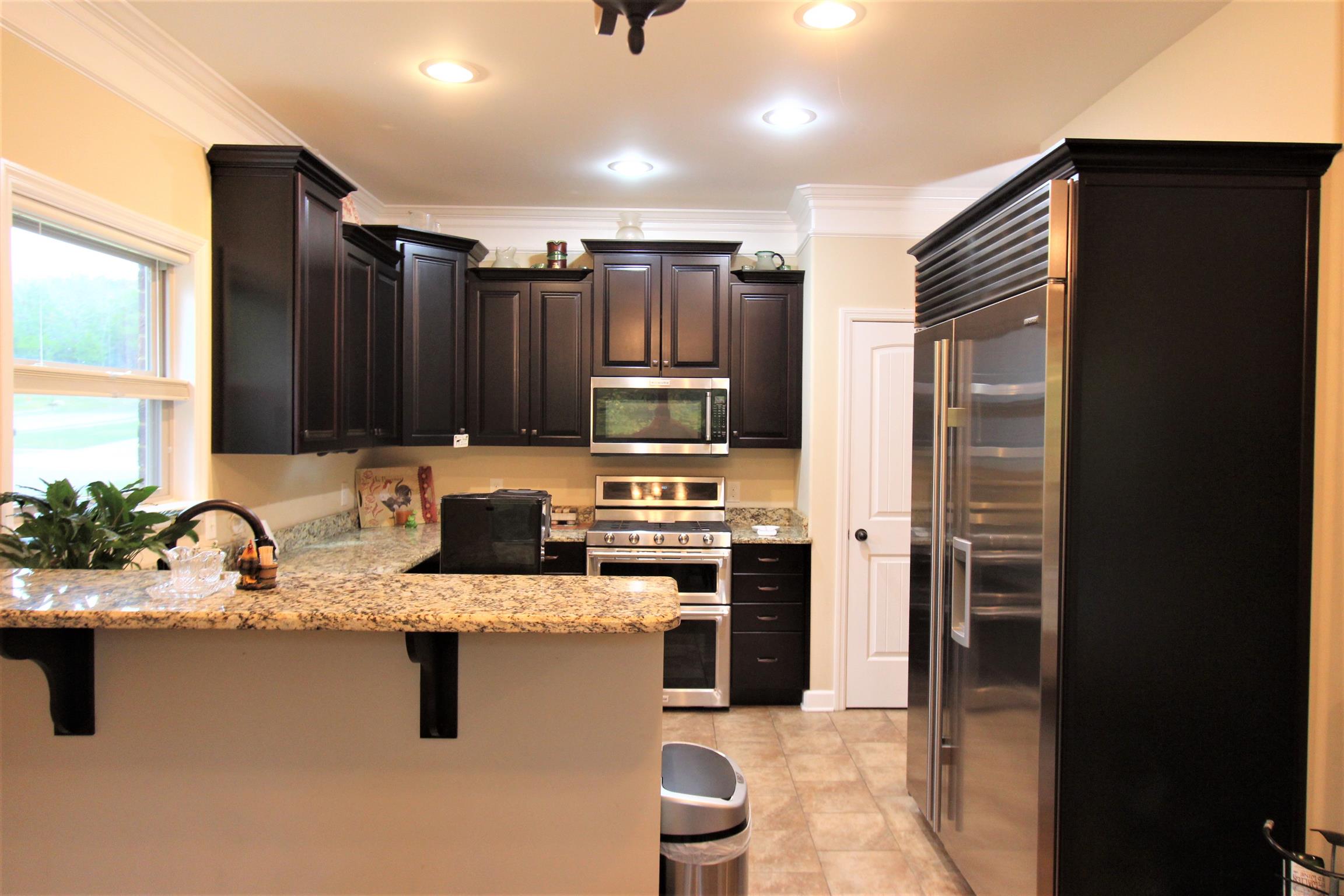 396 Abbey Road Lebanon, TN 37090 - Photo 8 of 23 a kitchen with stainless steel appliances granite countertop a refrigerator a stove and a sink with wooden cabinets