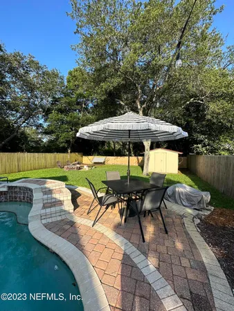 an outdoor sitting area with furniture and umbrella