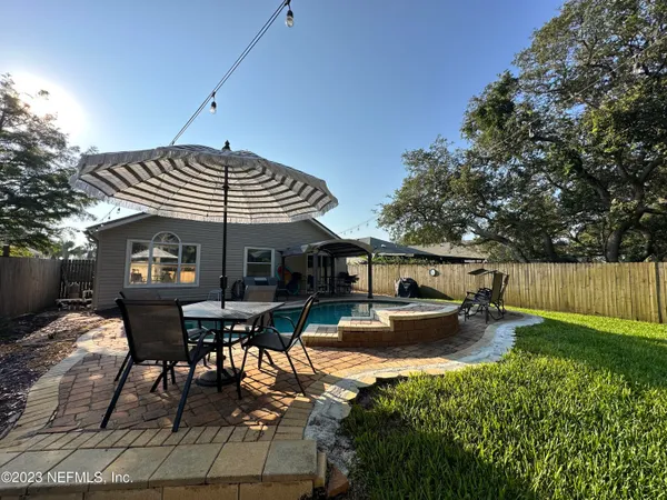 a view of a patio with table and chairs under an umbrella